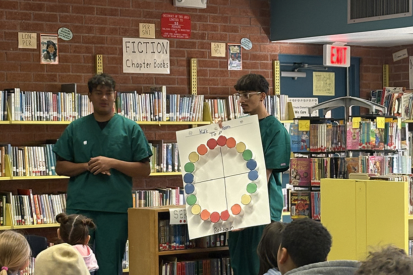 Dental students hold up a colorful poster