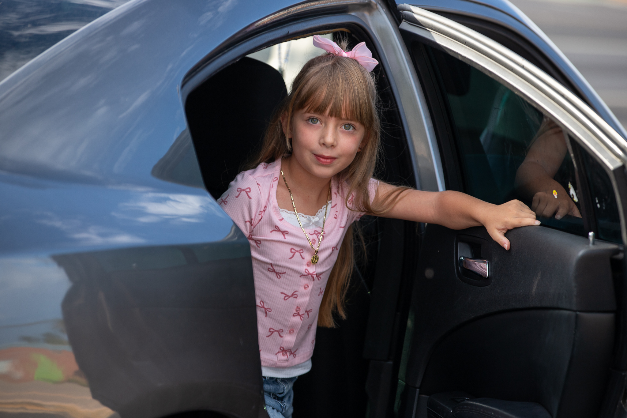 A little girl gets out of her family's car
